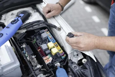 Mechanik przeglądający stan elektroniki pojazdu.